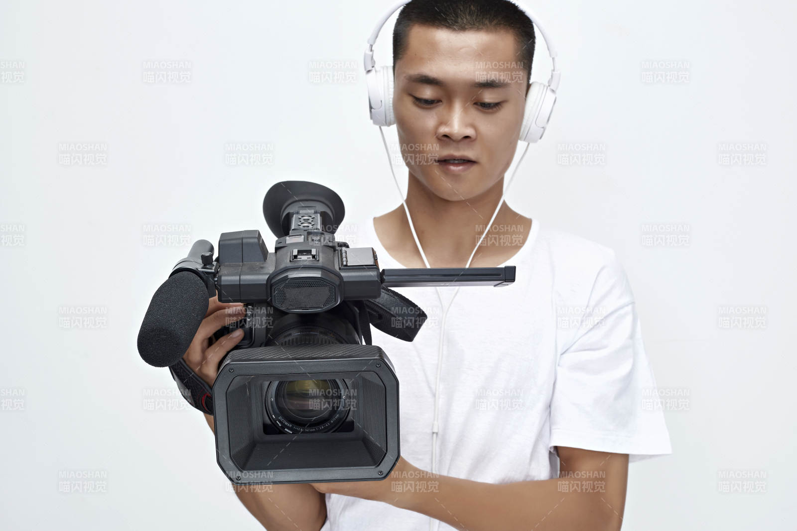 白色背景下手持攝像機進行錄制拍攝的攝像師