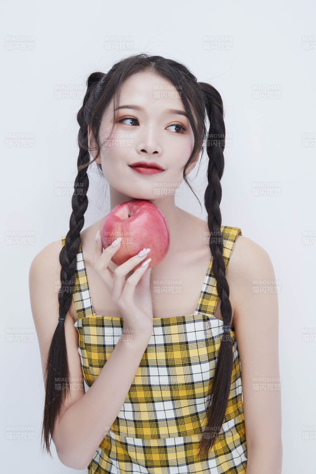 手拿蘋(píng)果身穿格子吊帶裙的亞洲可愛(ài)少女人像