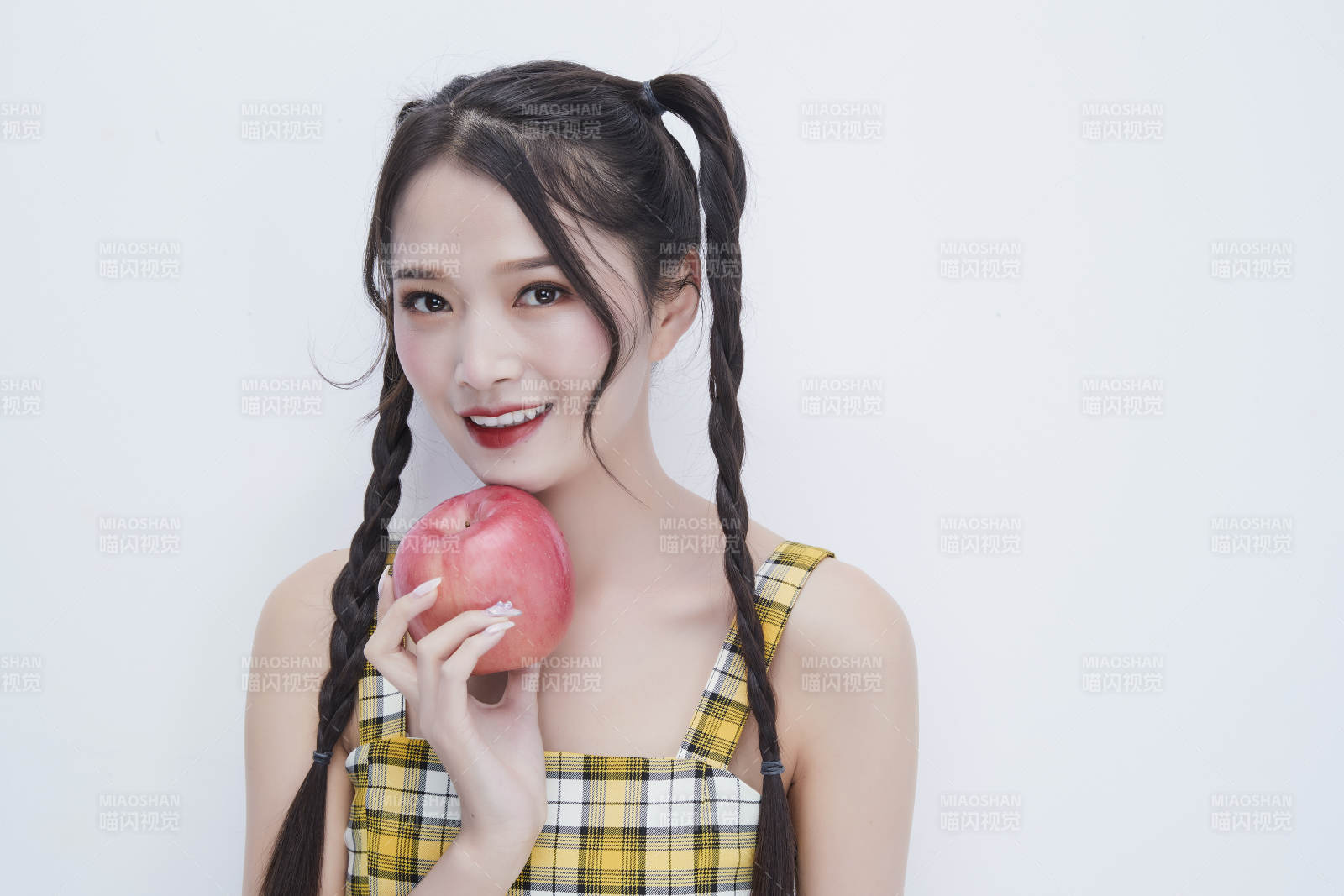 手拿蘋果身穿格子吊帶裙的亞洲可愛少女人像