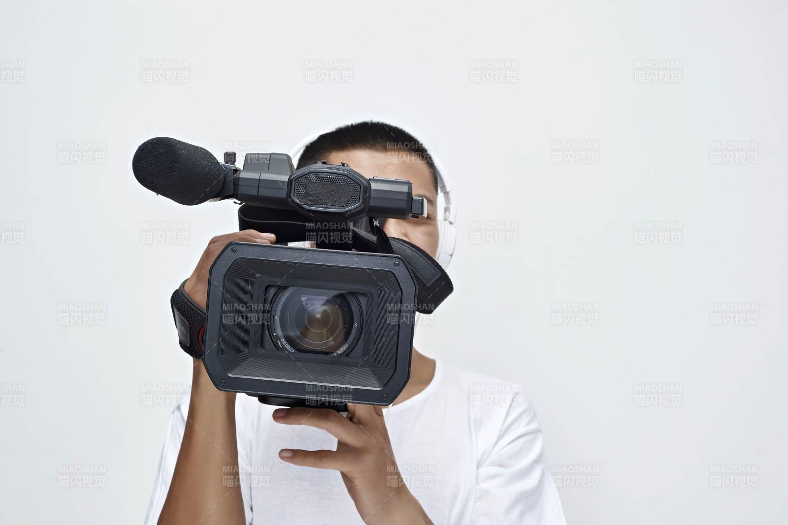 白色背景下手持攝像機進行錄制拍攝的攝像師
