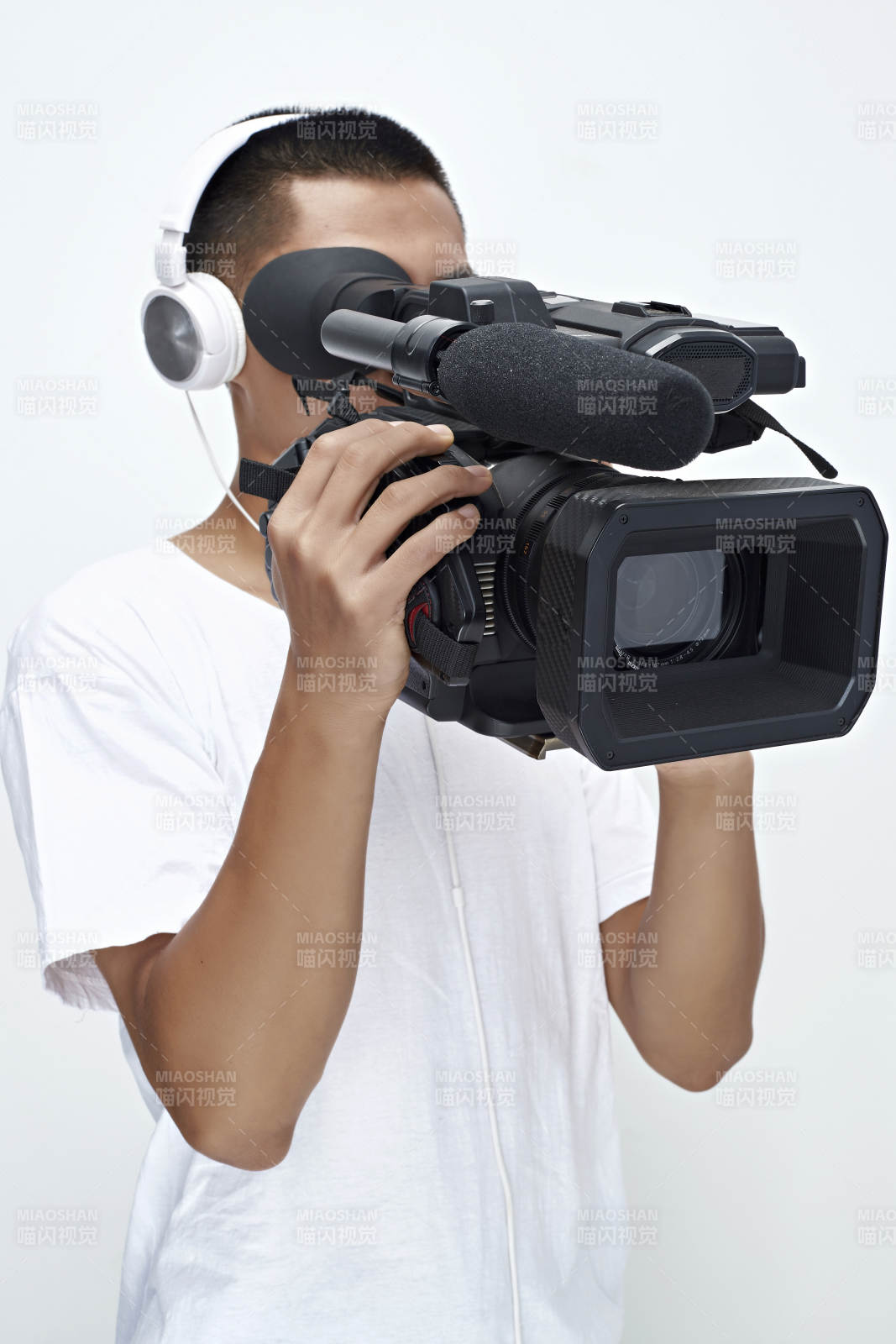 白色背景下手持攝像機進行錄制拍攝的攝像師