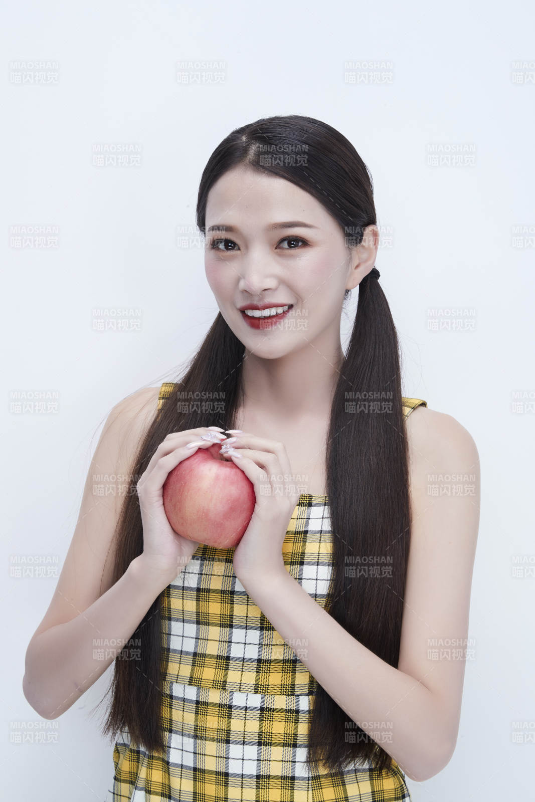 手拿蘋(píng)果身穿格子吊帶裙的亞洲可愛(ài)少女人像