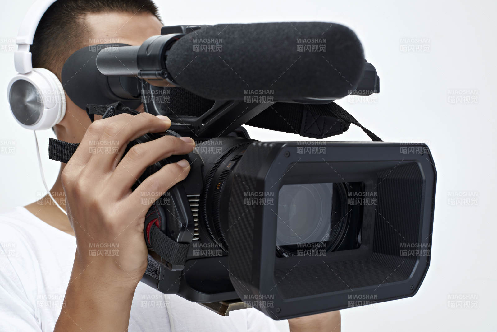 白色背景下手持?jǐn)z像機(jī)進(jìn)行錄制拍攝的攝像師