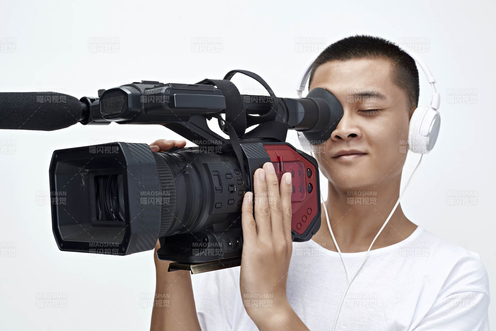 白色背景下手持摄像机进行录制拍摄的摄像师