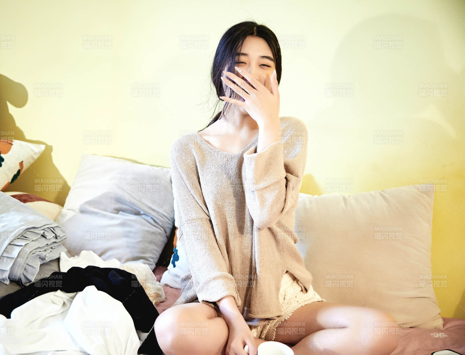 在沙發床上整理行裝的年輕亞洲女性