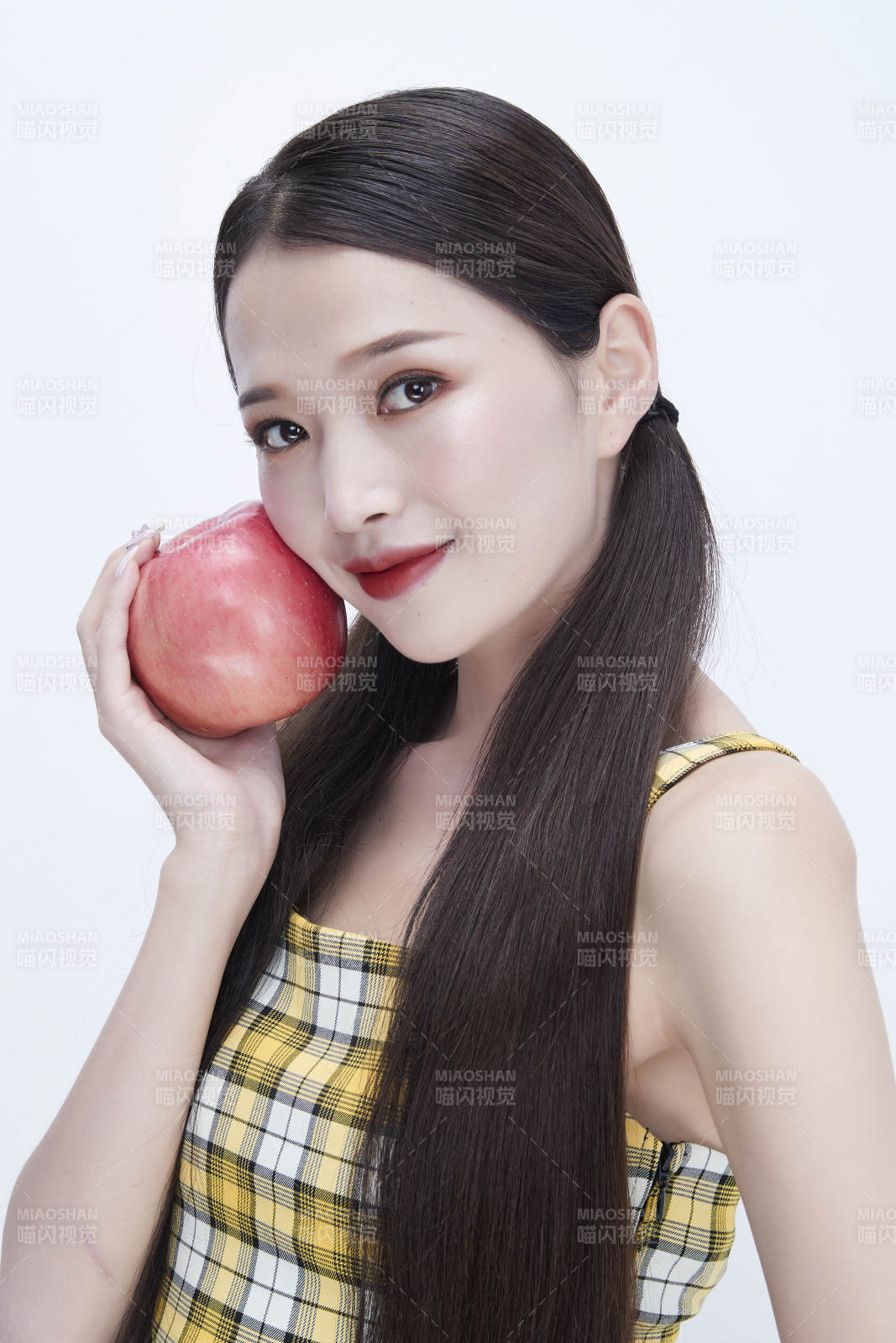 手拿蘋果身穿格子吊帶裙的亞洲可愛少女人像