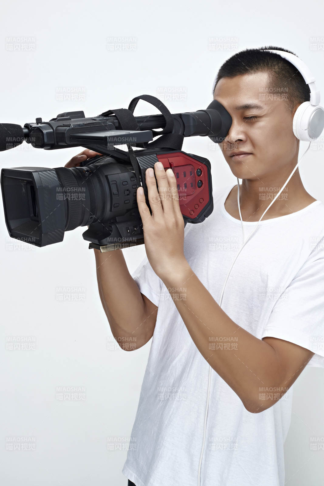 白色背景下手持攝像機進行錄制拍攝的攝像師