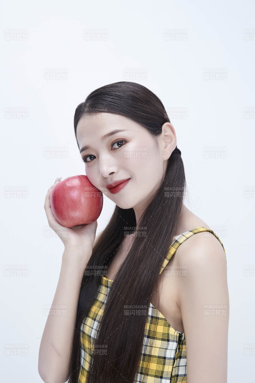 手拿蘋果身穿格子吊帶裙的亞洲可愛少女人像