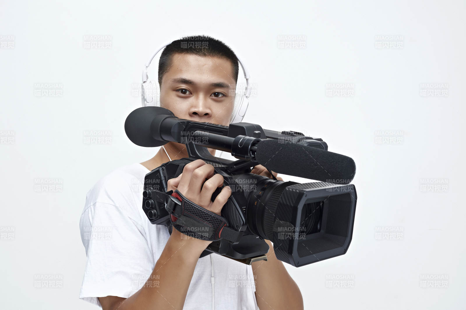 白色背景下手持攝像機進行錄制拍攝的攝像師