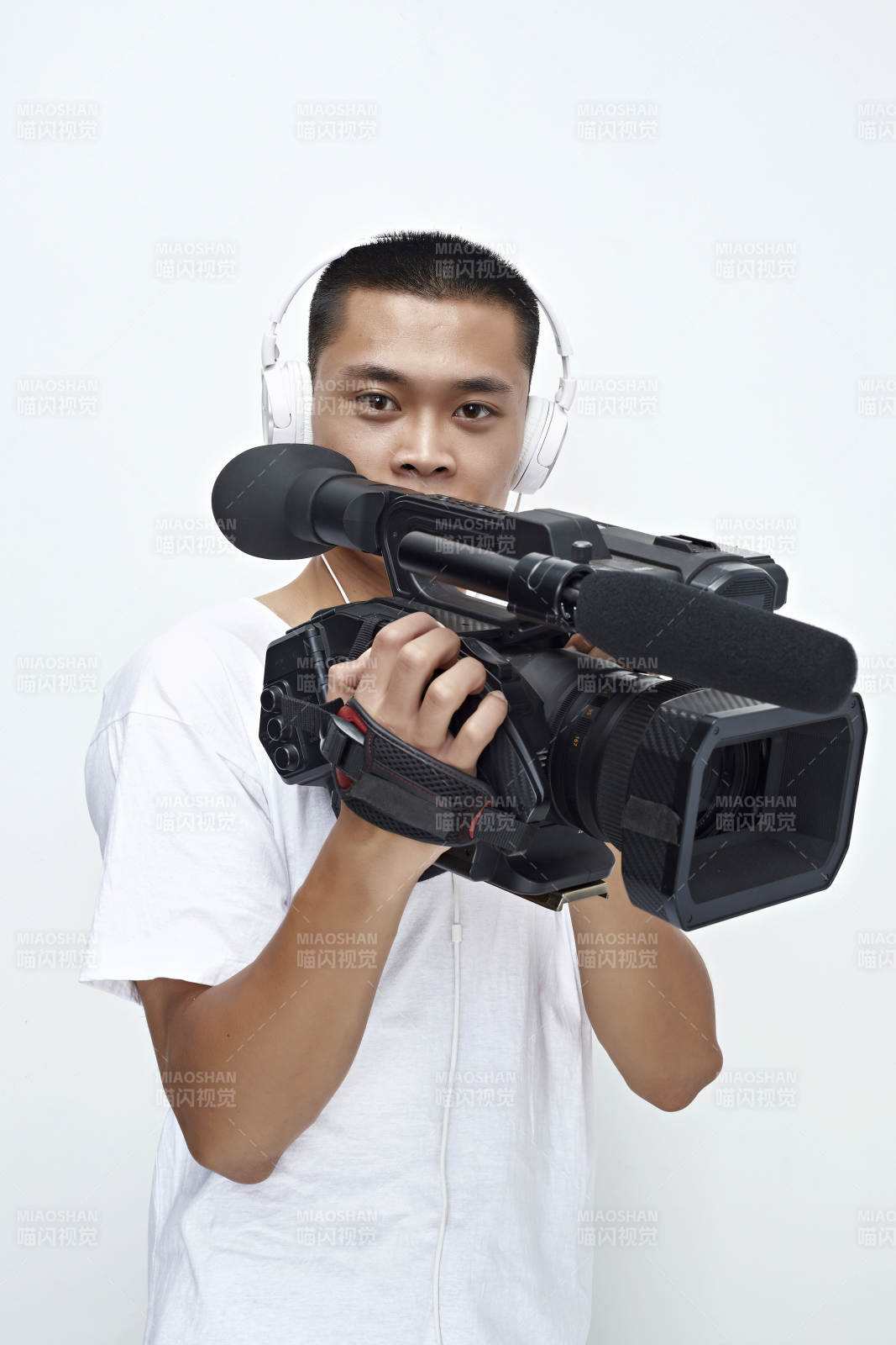白色背景下手持攝像機進行錄制拍攝的攝像師