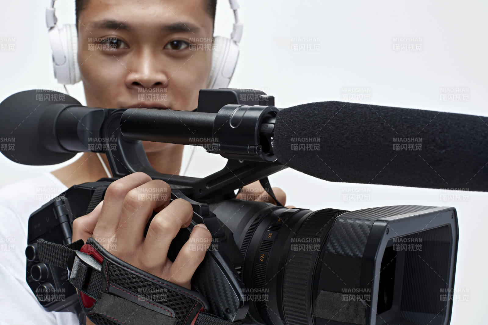 白色背景下手持?jǐn)z像機(jī)進(jìn)行錄制拍攝的攝像師