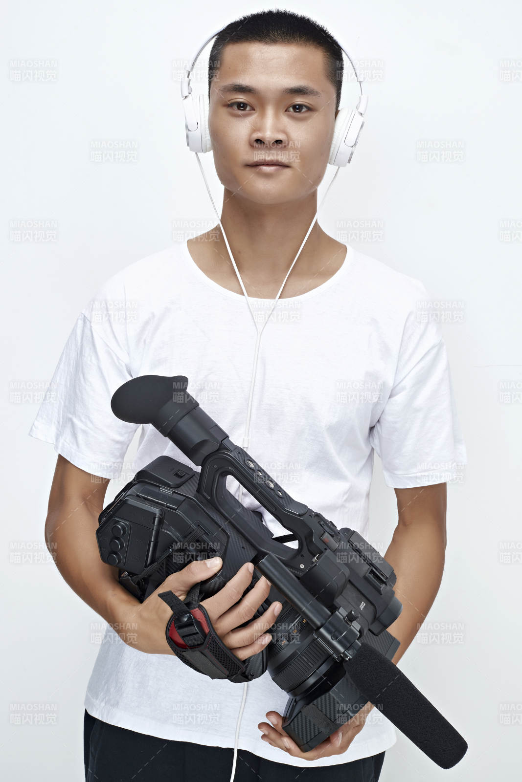 白色背景下手持攝像機進行錄制拍攝的攝像師