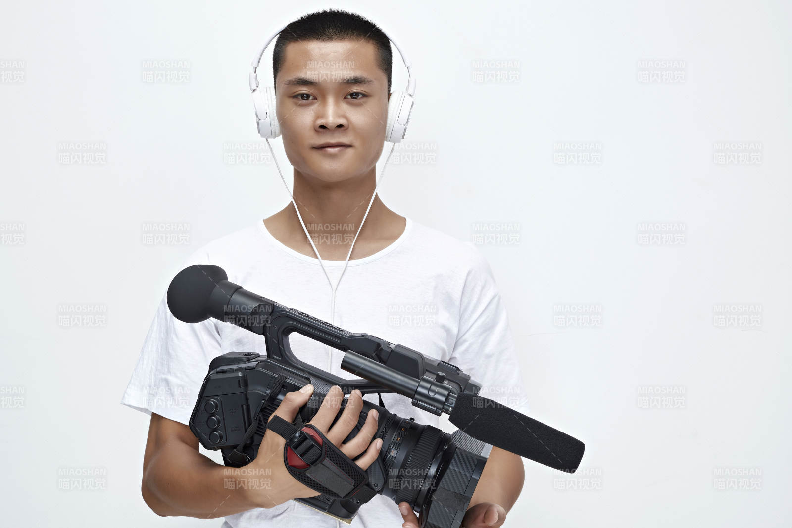 白色背景下手持攝像機進行錄制拍攝的攝像師