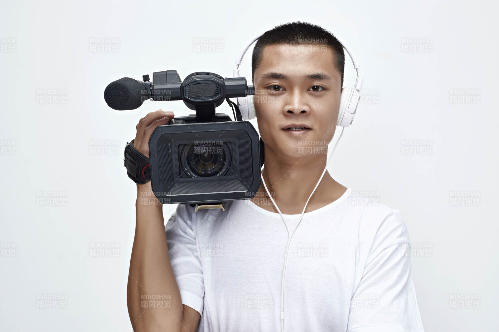 白色背景下手持摄像机进行录制拍摄的摄像师
