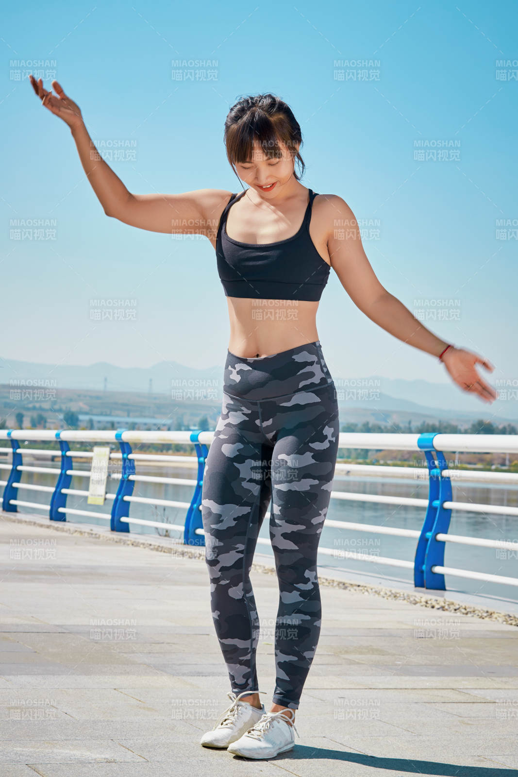 戶外河畔公園做拉伸有氧運動的亞洲女性