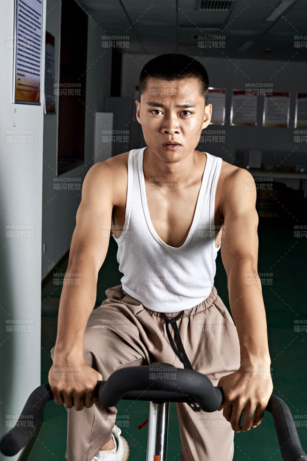 在室內(nèi)進(jìn)行動(dòng)感單車鍛煉的亞洲健身男士形象