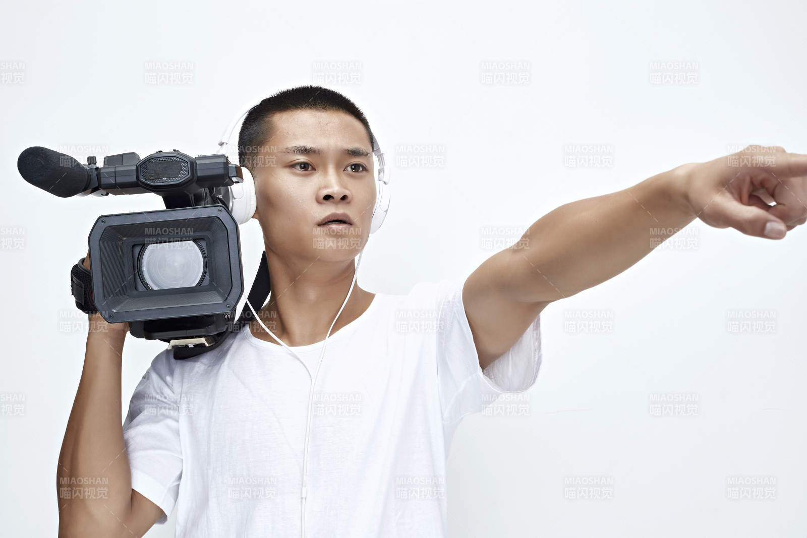 白色背景下手持攝像機進行錄制拍攝的攝像師
