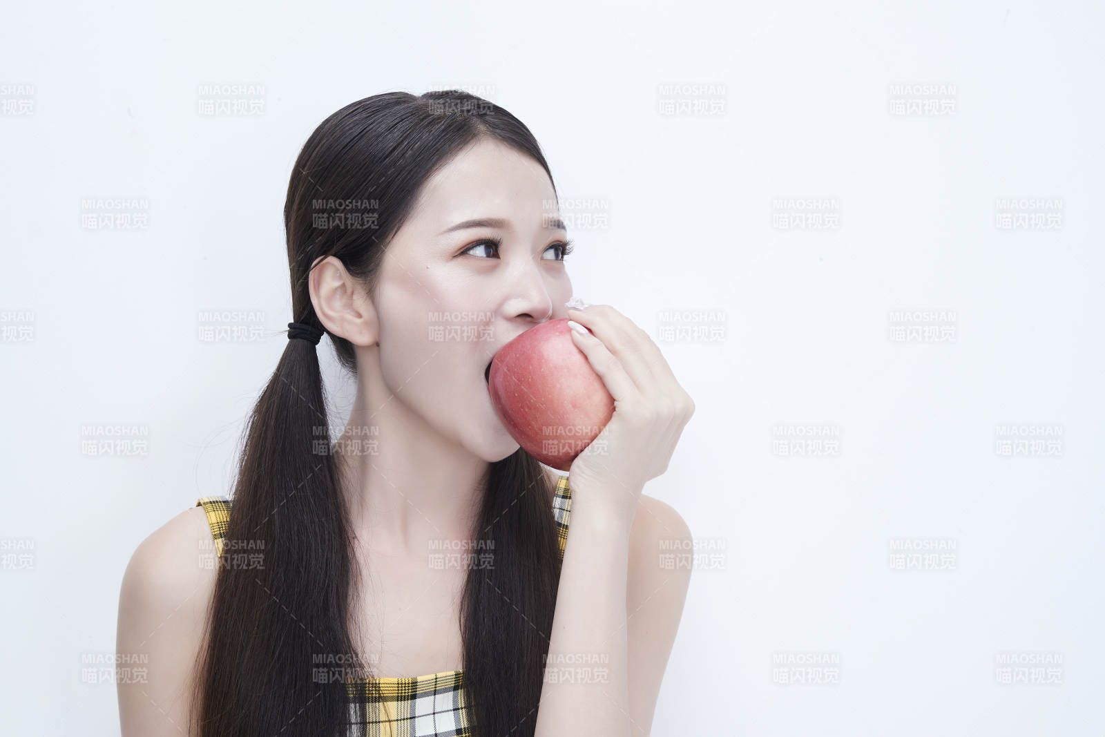 手拿蘋果身穿格子吊帶裙的亞洲可愛少女人像