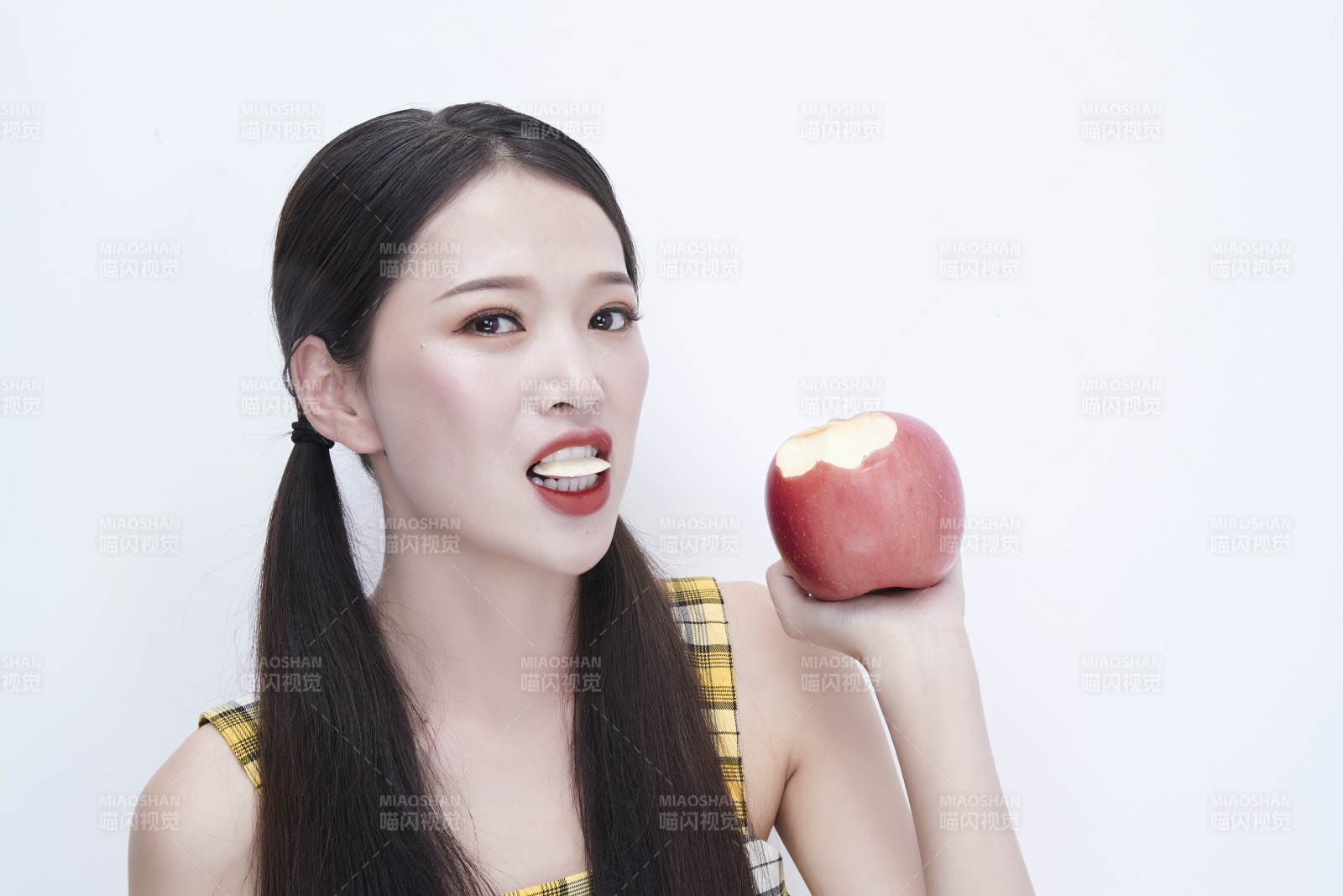 手拿蘋果身穿格子吊帶裙的亞洲可愛少女人像
