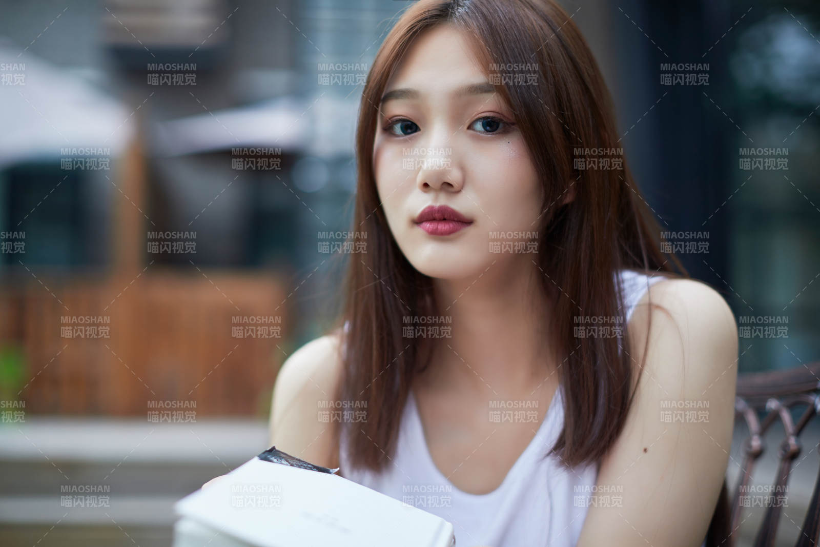 院子里坐在长椅上阅读书籍的亚洲长发少女