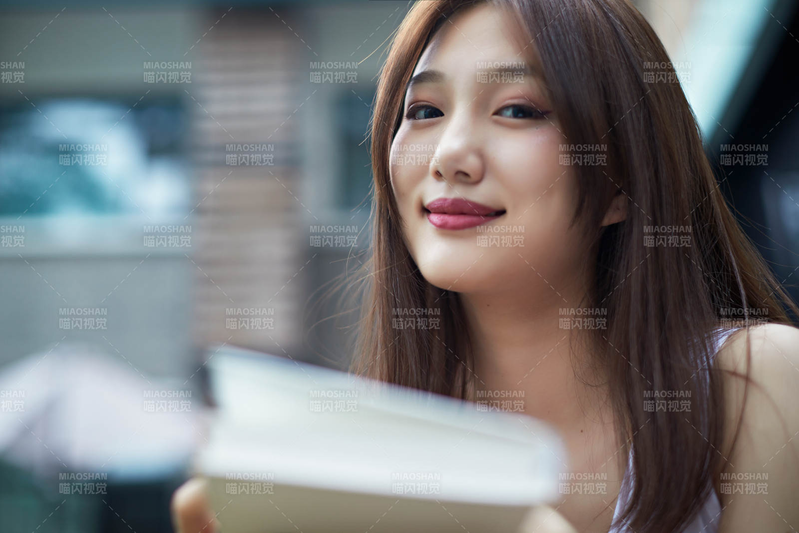 院子里坐在長椅上閱讀書籍的亞洲長發少女