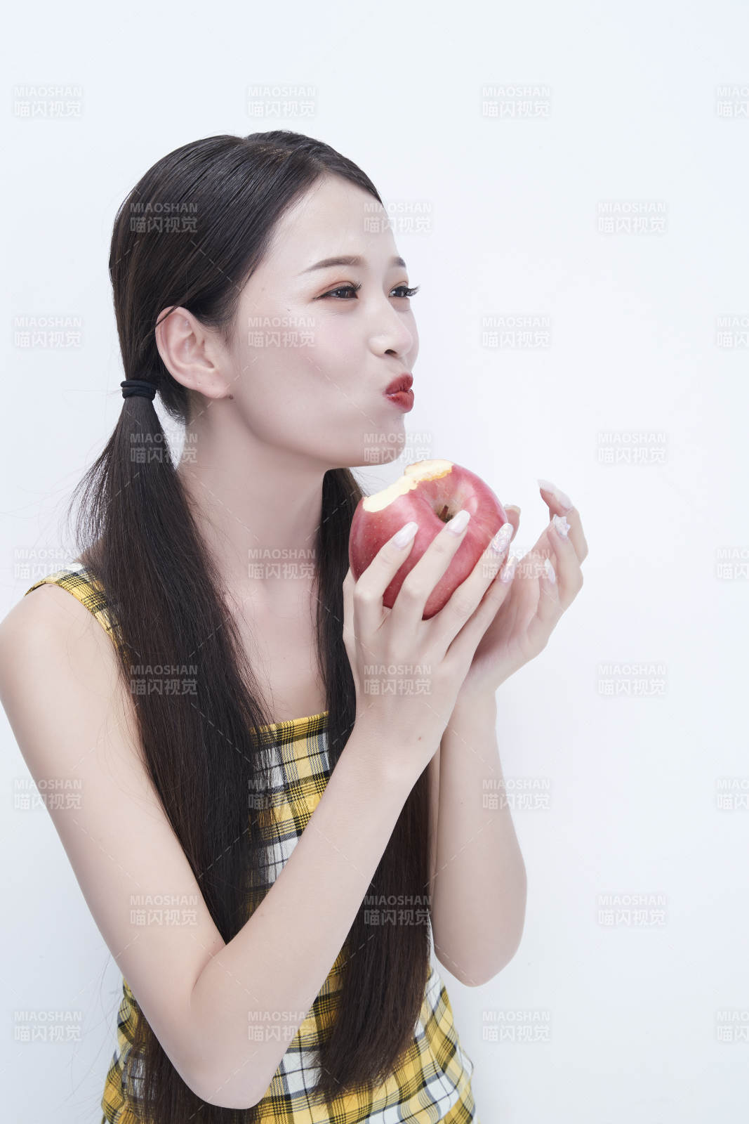 手拿蘋果身穿格子吊帶裙的亞洲可愛少女人像