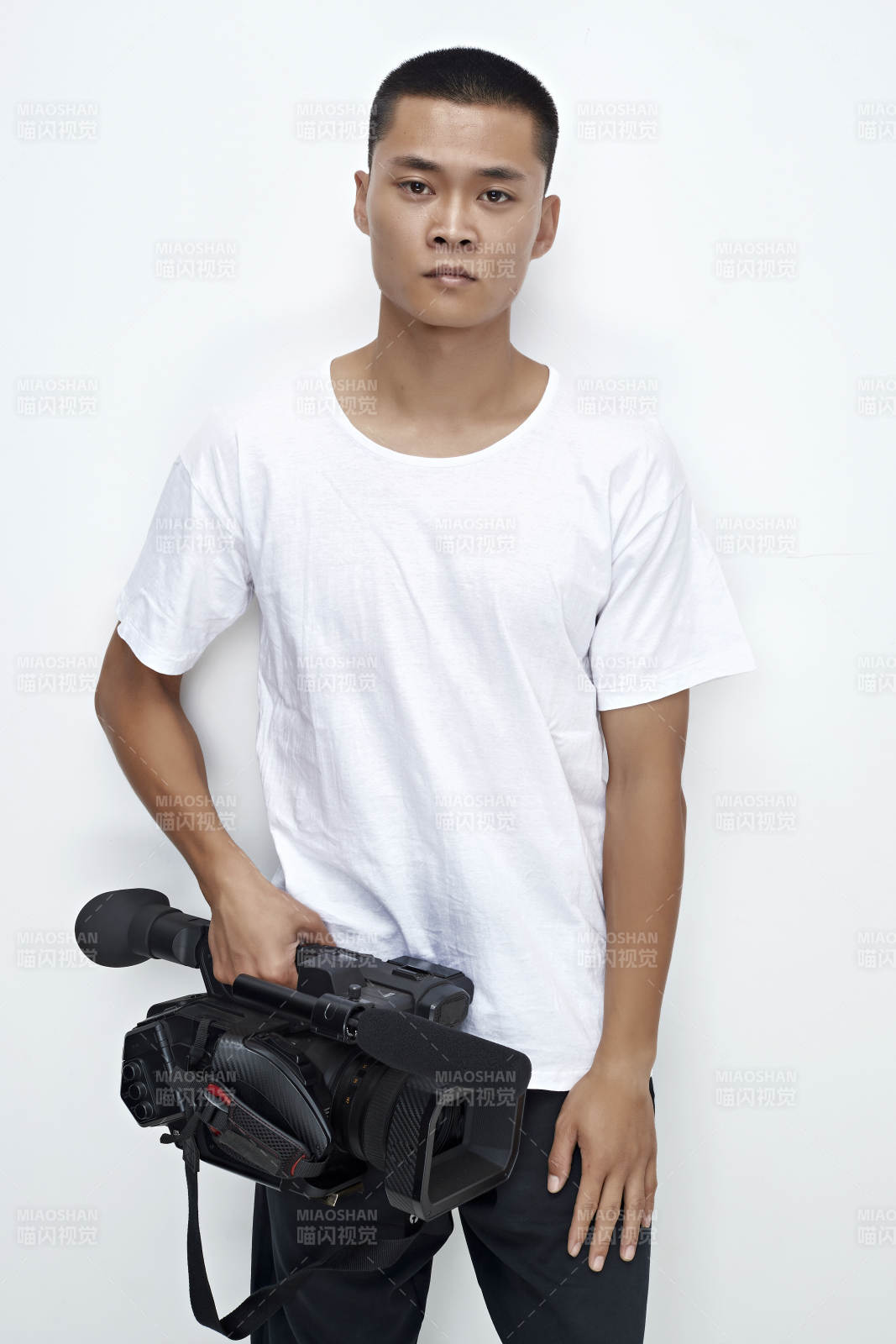 白色背景下手持攝像機進行錄制拍攝的攝像師