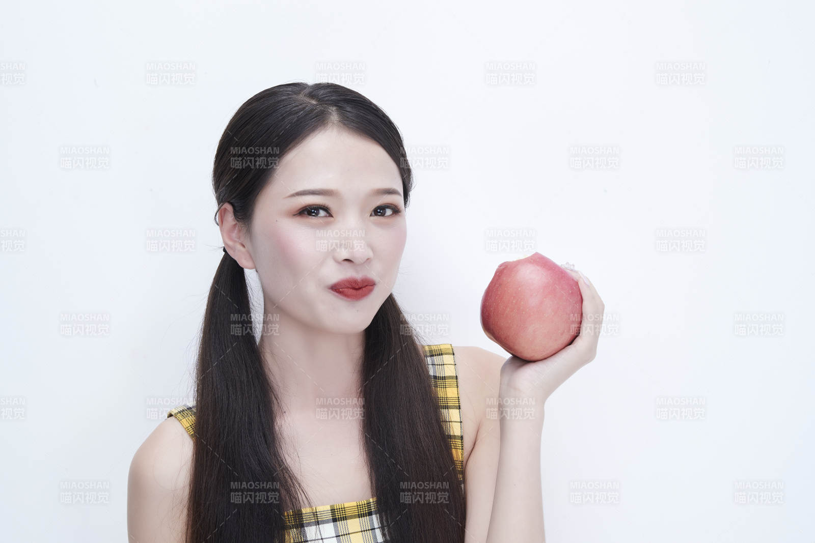 手拿蘋果身穿格子吊帶裙的亞洲可愛少女人像
