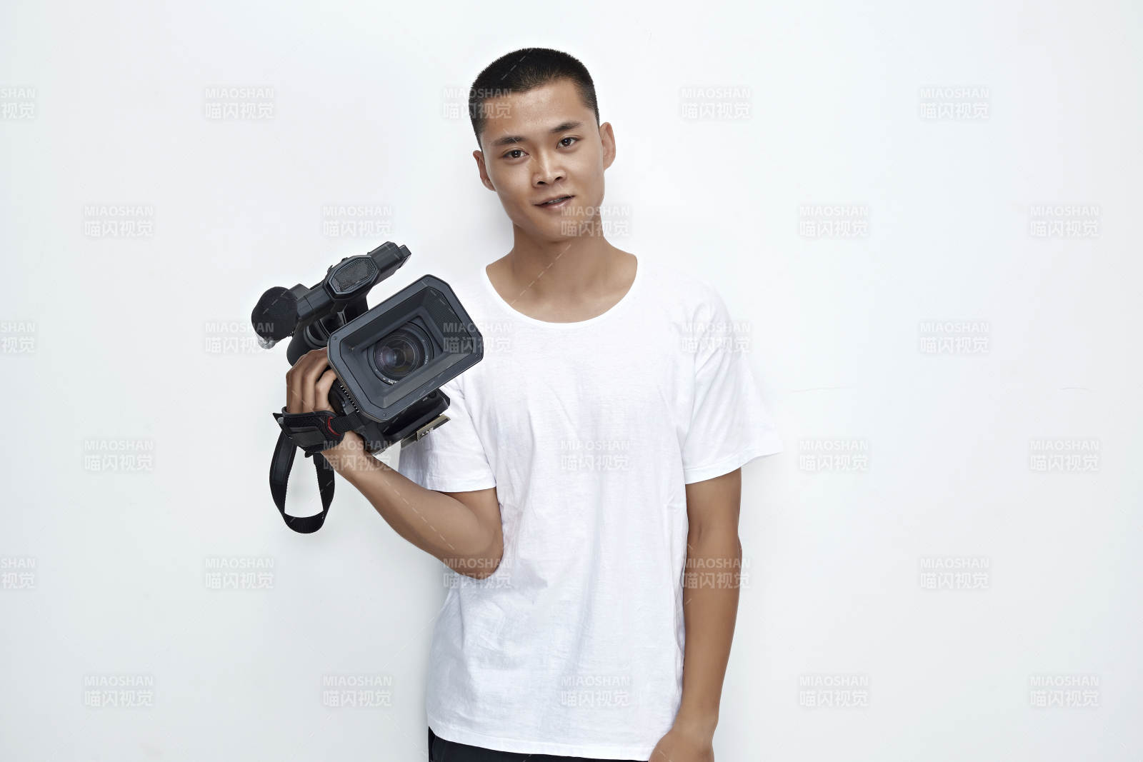白色背景下手持摄像机进行录制拍摄的摄像师