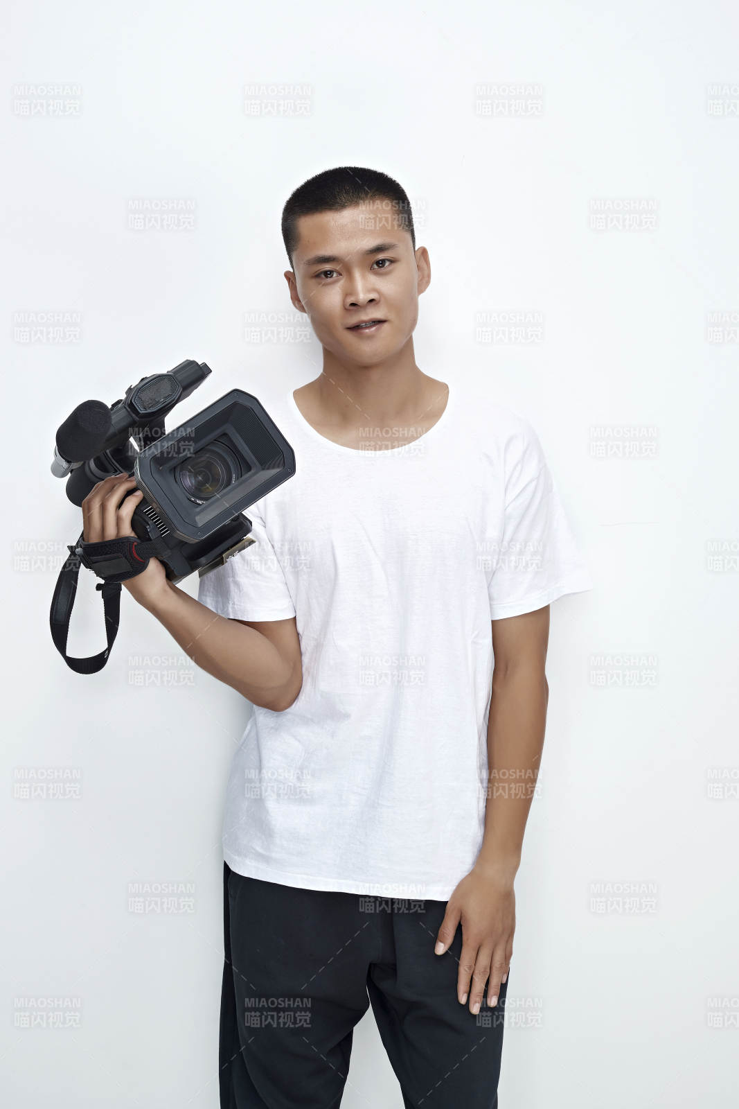 白色背景下手持?jǐn)z像機(jī)進(jìn)行錄制拍攝的攝像師