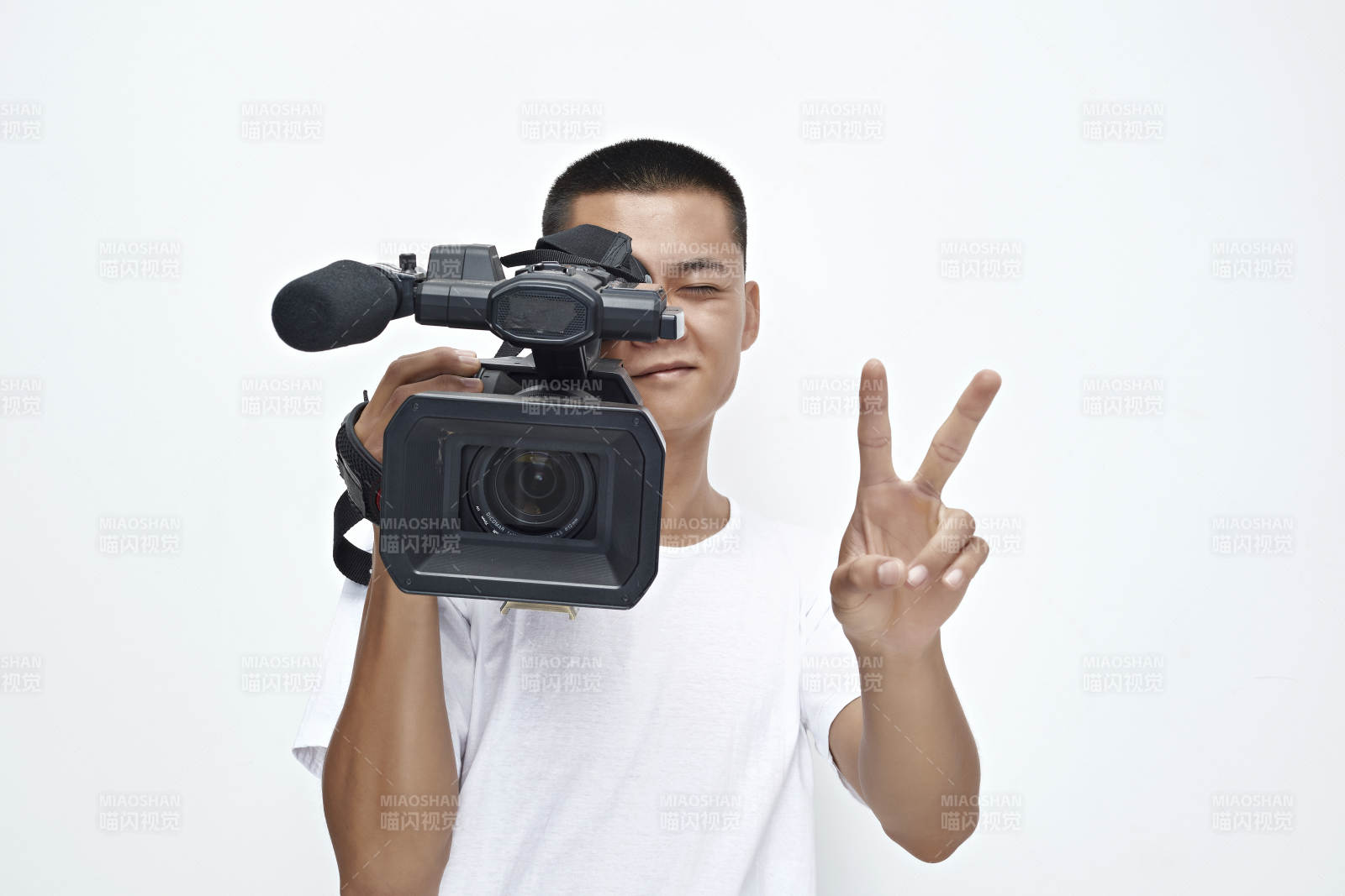 白色背景下手持攝像機進行錄制拍攝的攝像師