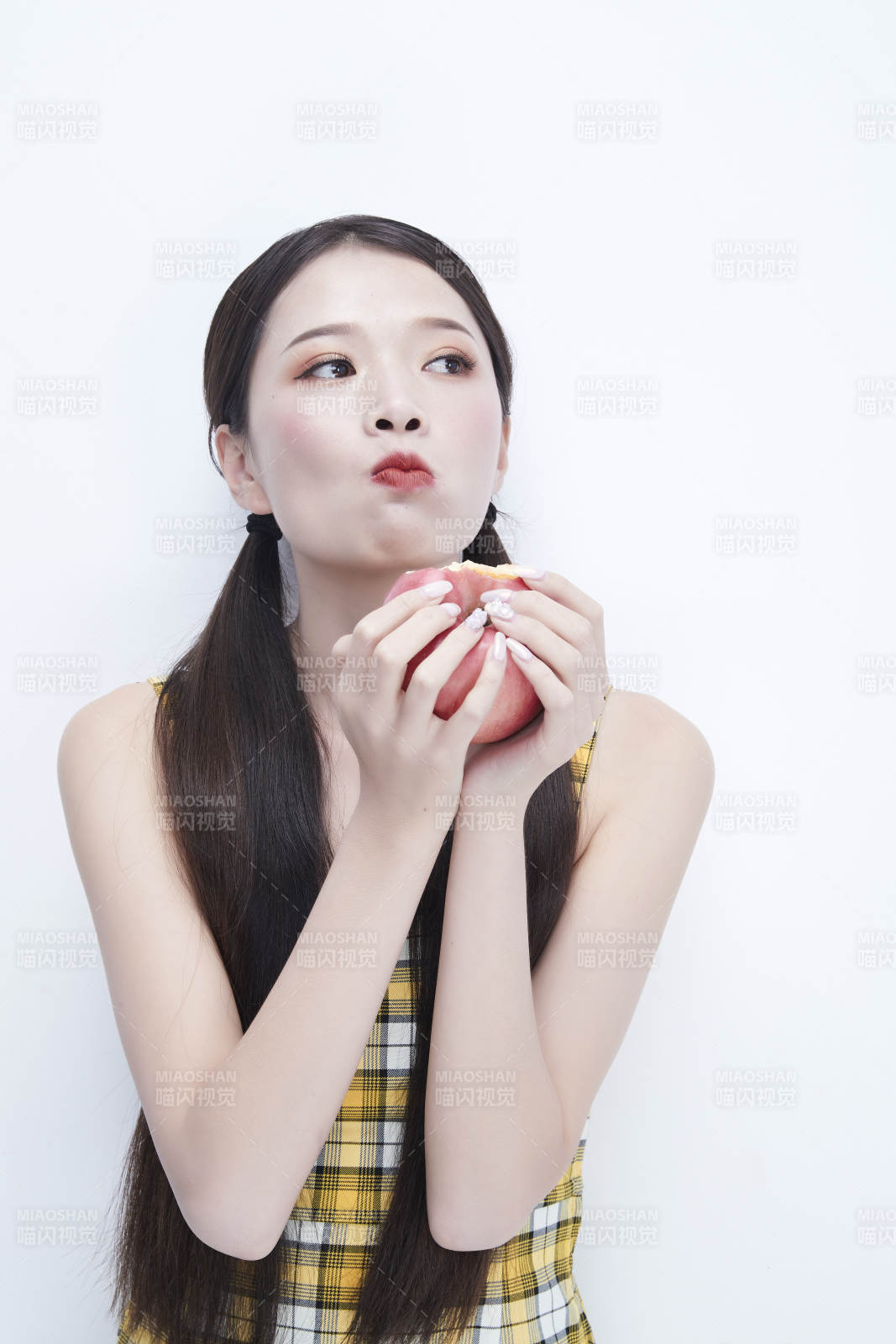 手拿蘋果身穿格子吊帶裙的亞洲可愛少女人像