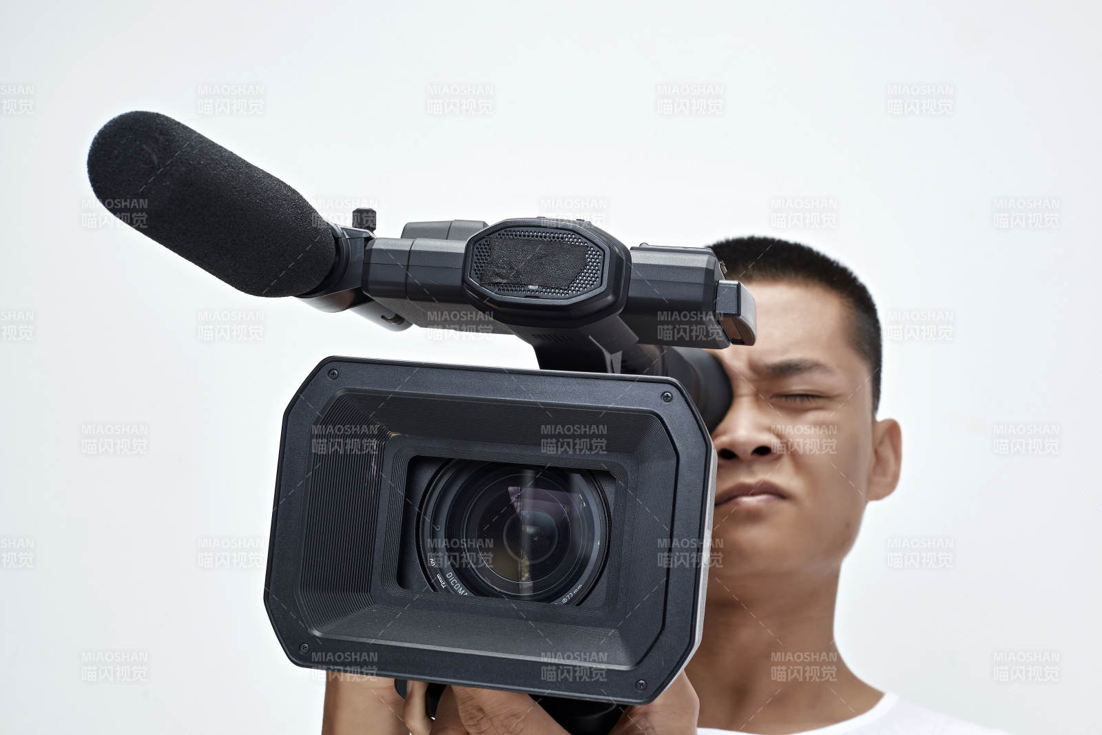 白色背景下手持攝像機進行錄制拍攝的攝像師