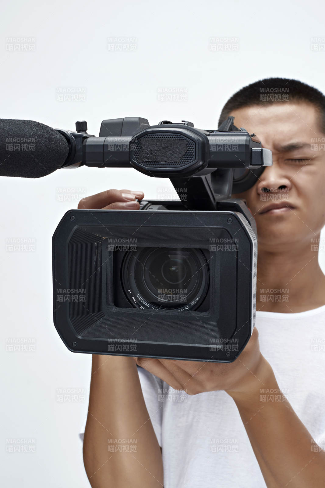 白色背景下手持攝像機進行錄制拍攝的攝像師