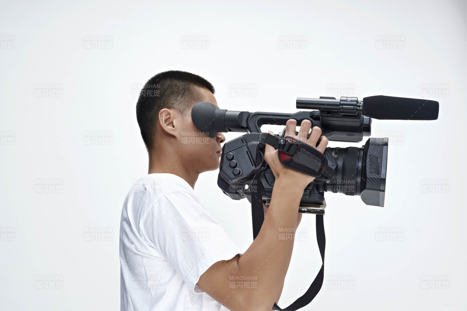 白色背景下手持?jǐn)z像機(jī)進(jìn)行錄制拍攝的攝像師
