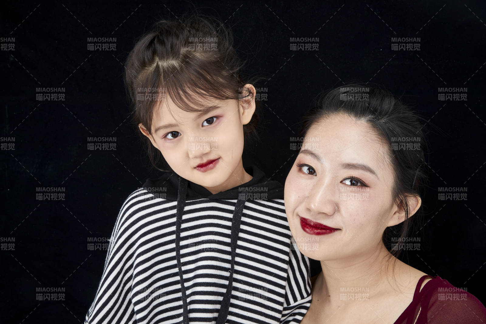 黑色背景的美麗媽媽與可愛女兒親子人像