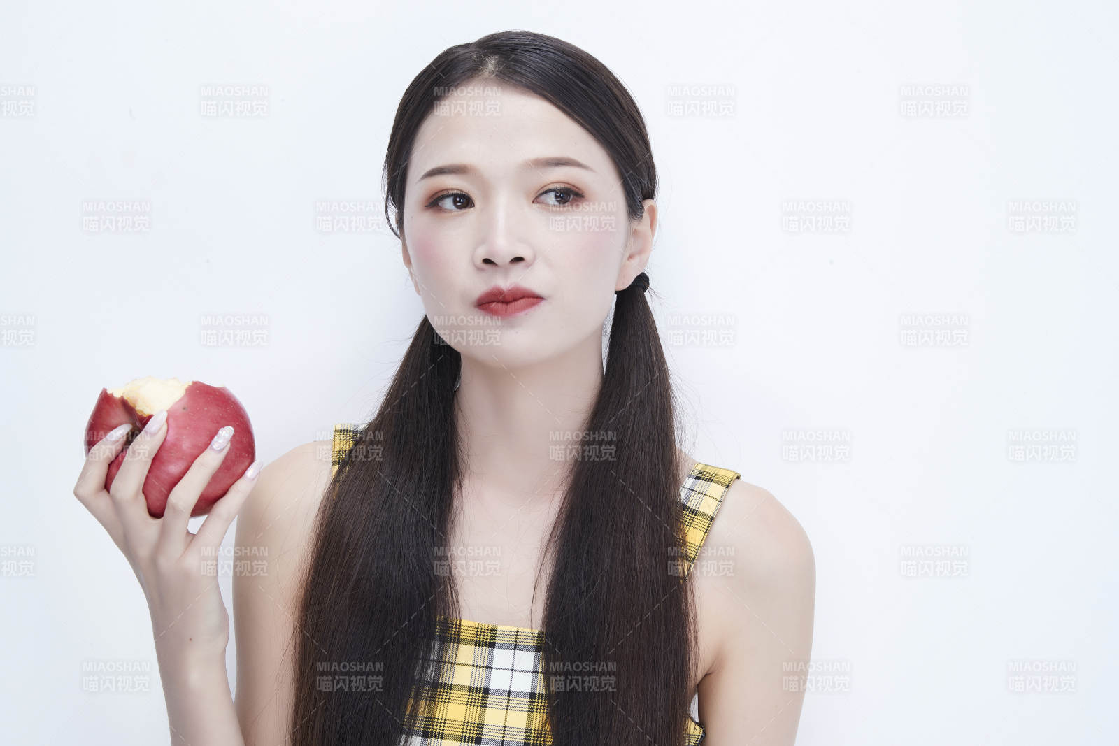 手拿蘋果身穿格子吊帶裙的亞洲可愛少女人像