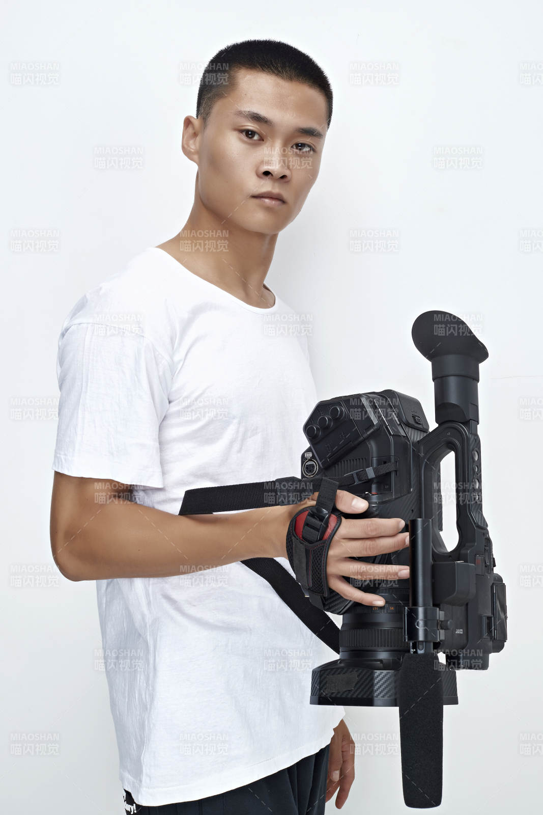 白色背景下手持摄像机进行录制拍摄的摄像师