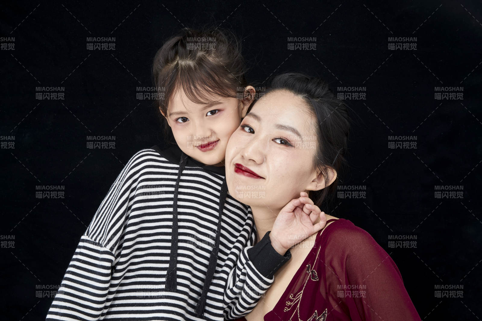 黑色背景的美麗媽媽與可愛女兒親子人像