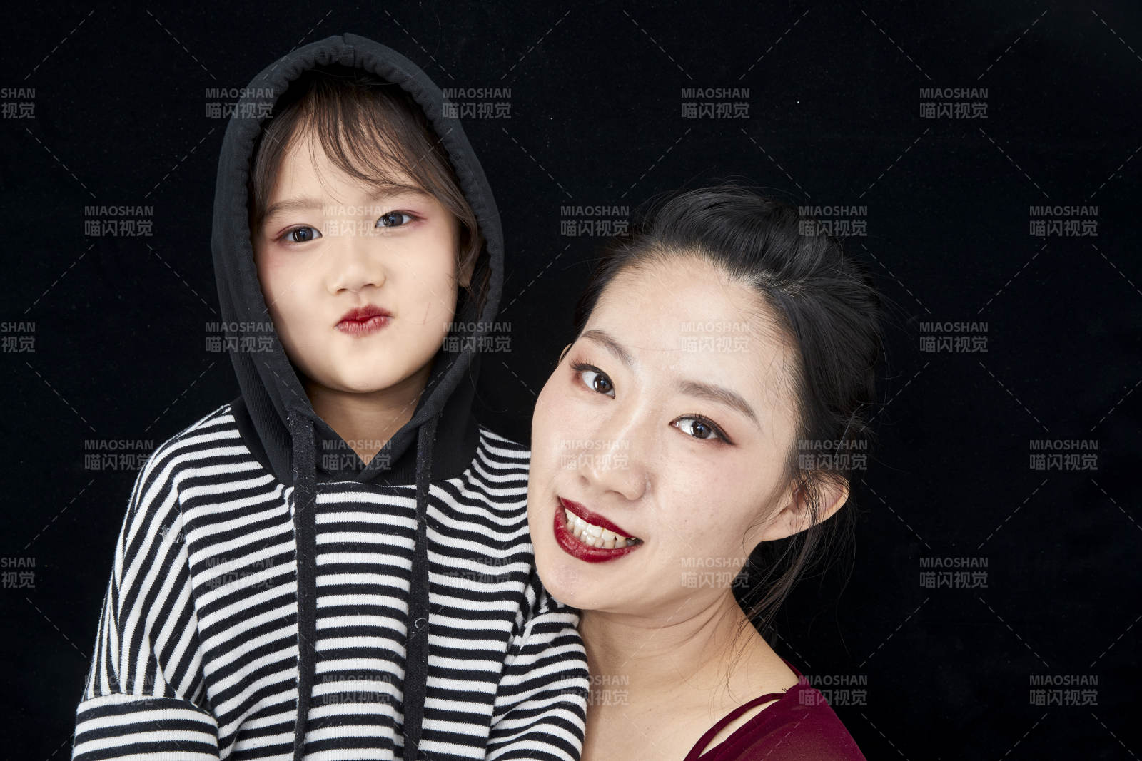 黑色背景的美麗媽媽與可愛女兒親子人像