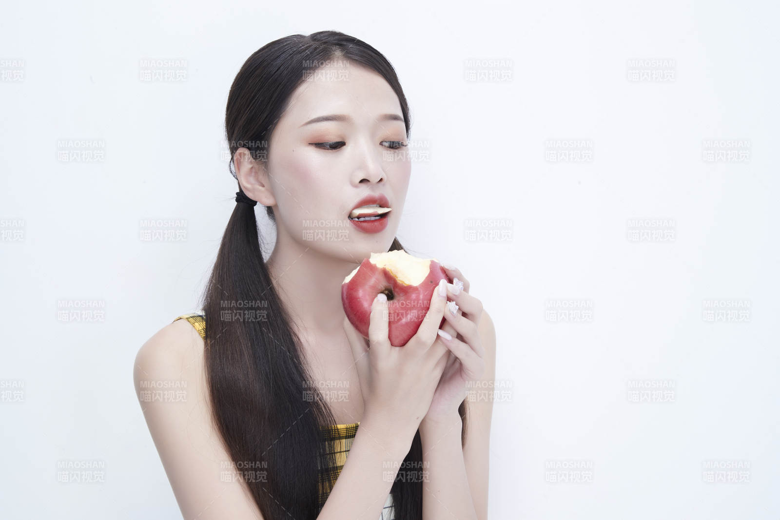 手拿蘋果身穿格子吊帶裙的亞洲可愛少女人像