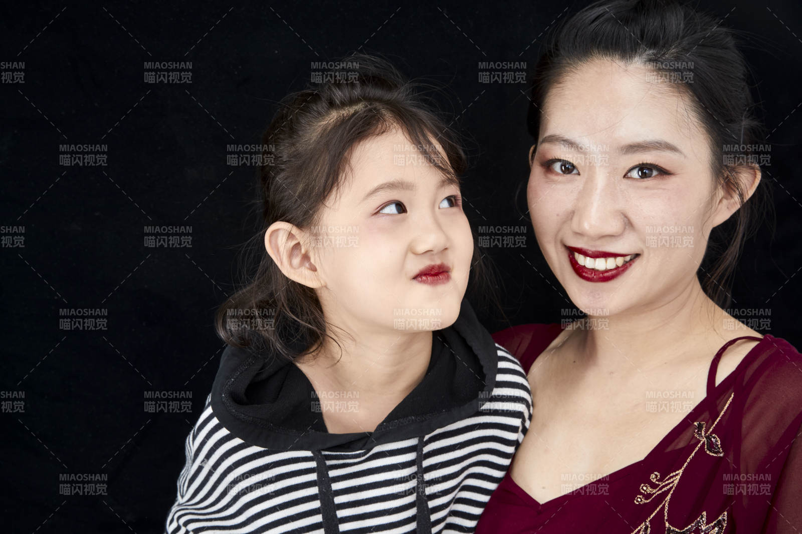 黑色背景的美麗媽媽與可愛女兒親子人像