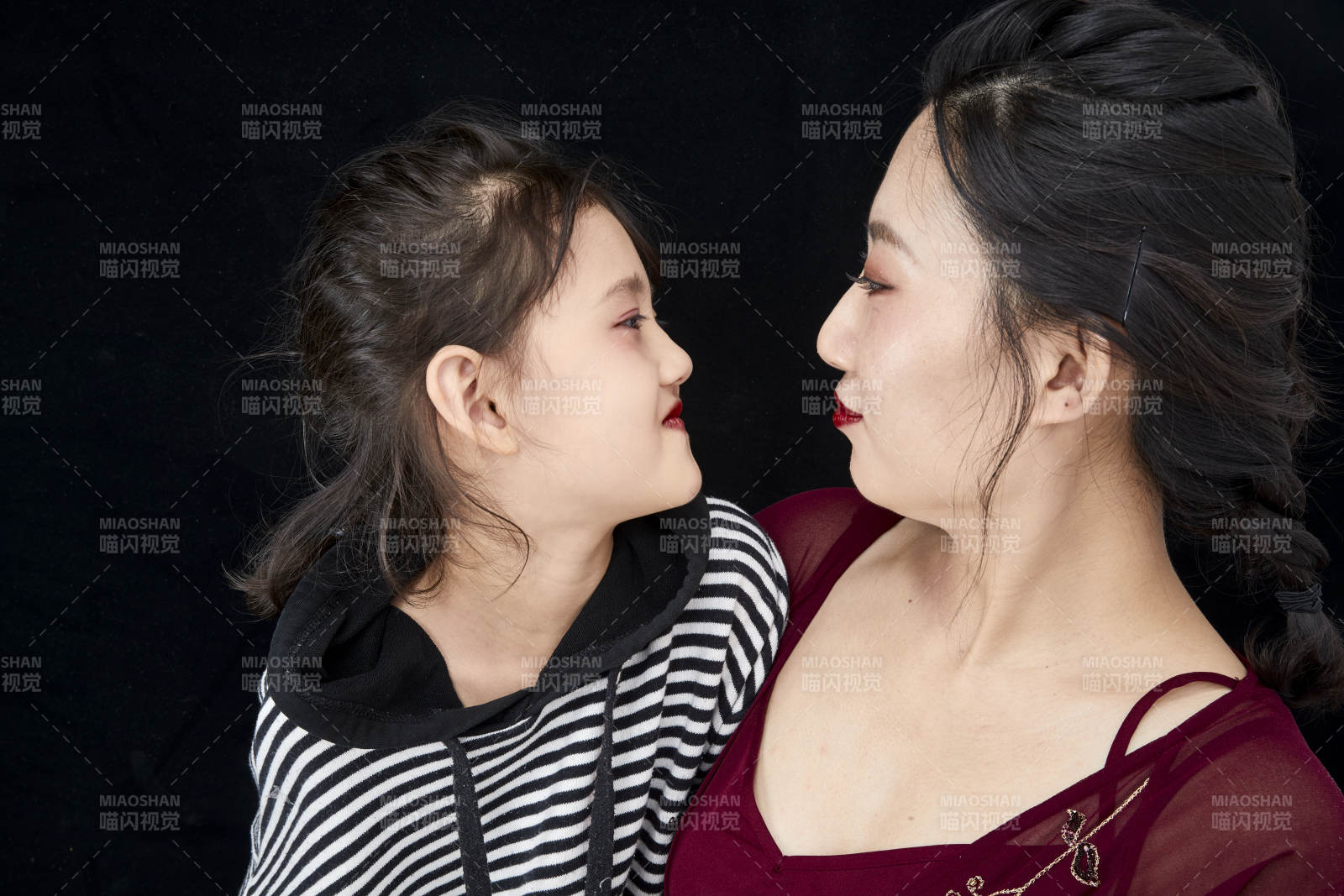 黑色背景的美麗媽媽與可愛女兒親子人像