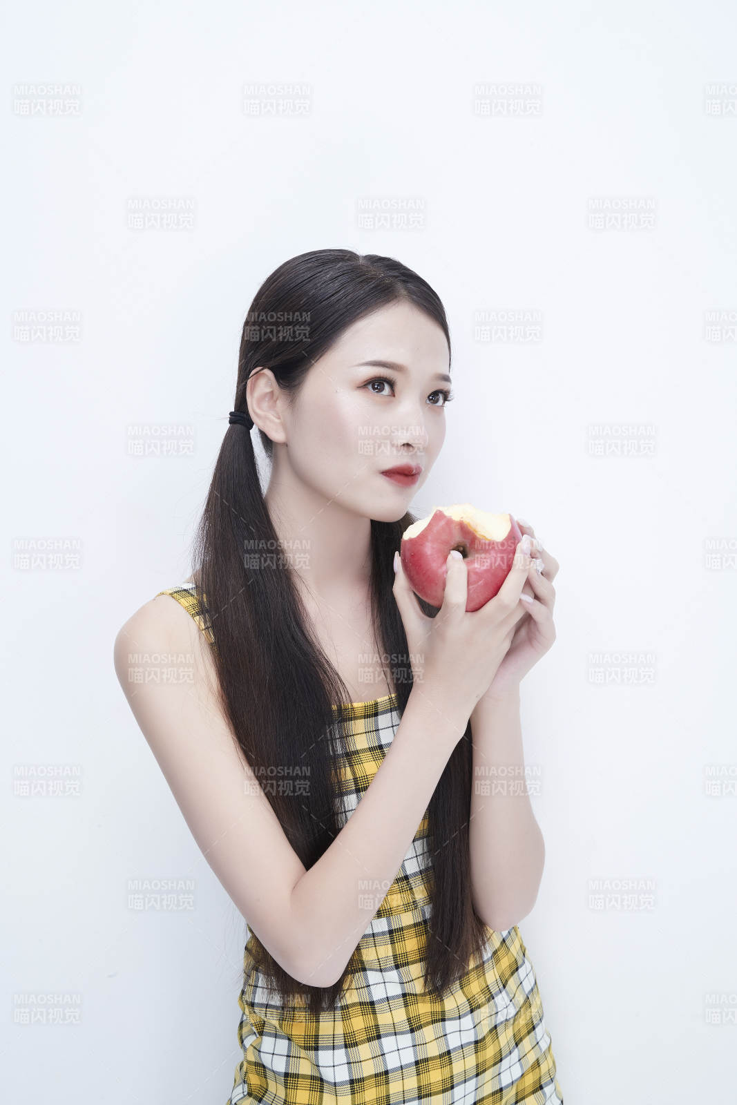 手拿蘋果身穿格子吊帶裙的亞洲可愛少女人像