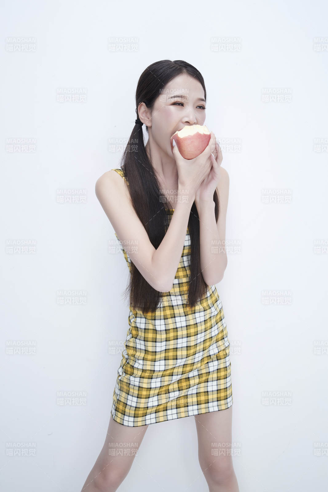 手拿蘋果身穿格子吊帶裙的亞洲可愛少女人像