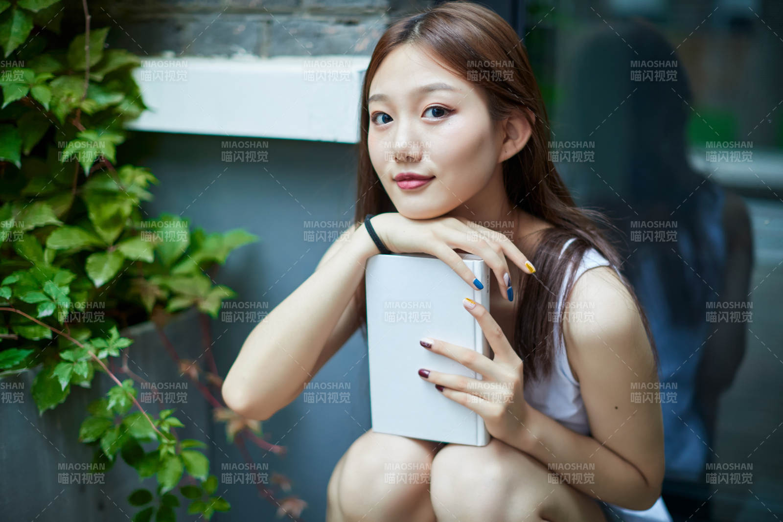 院子里坐在長椅上閱讀書籍的亞洲長發少女