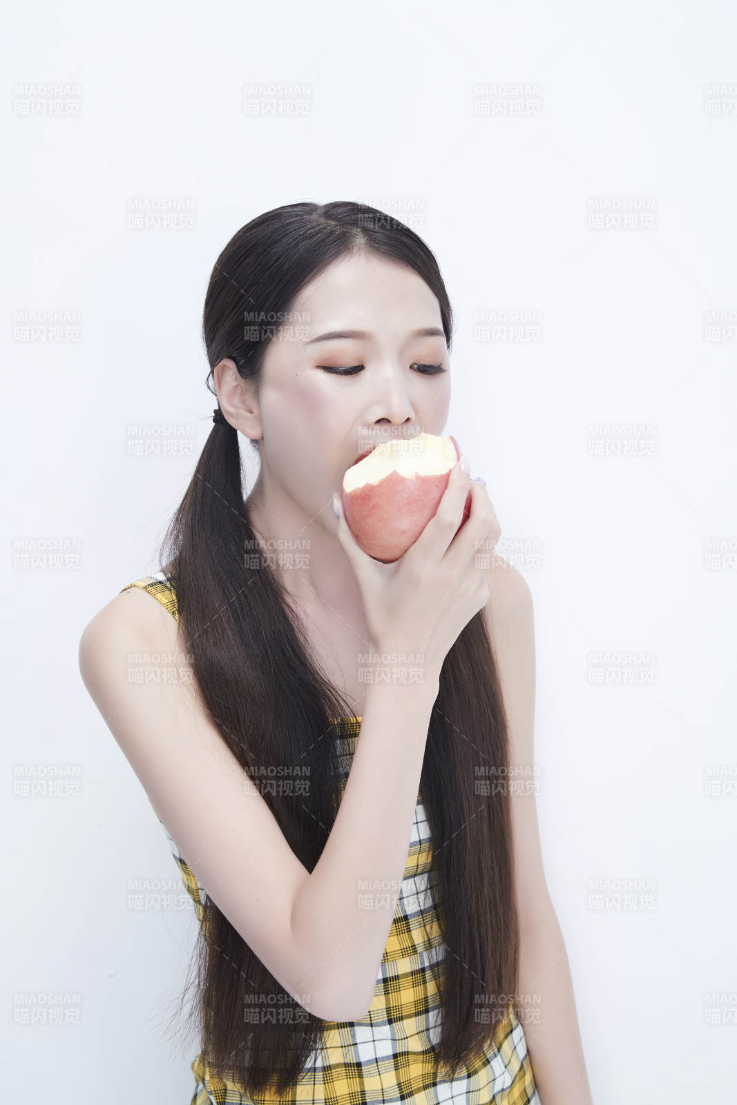 手拿蘋果身穿格子吊帶裙的亞洲可愛少女人像
