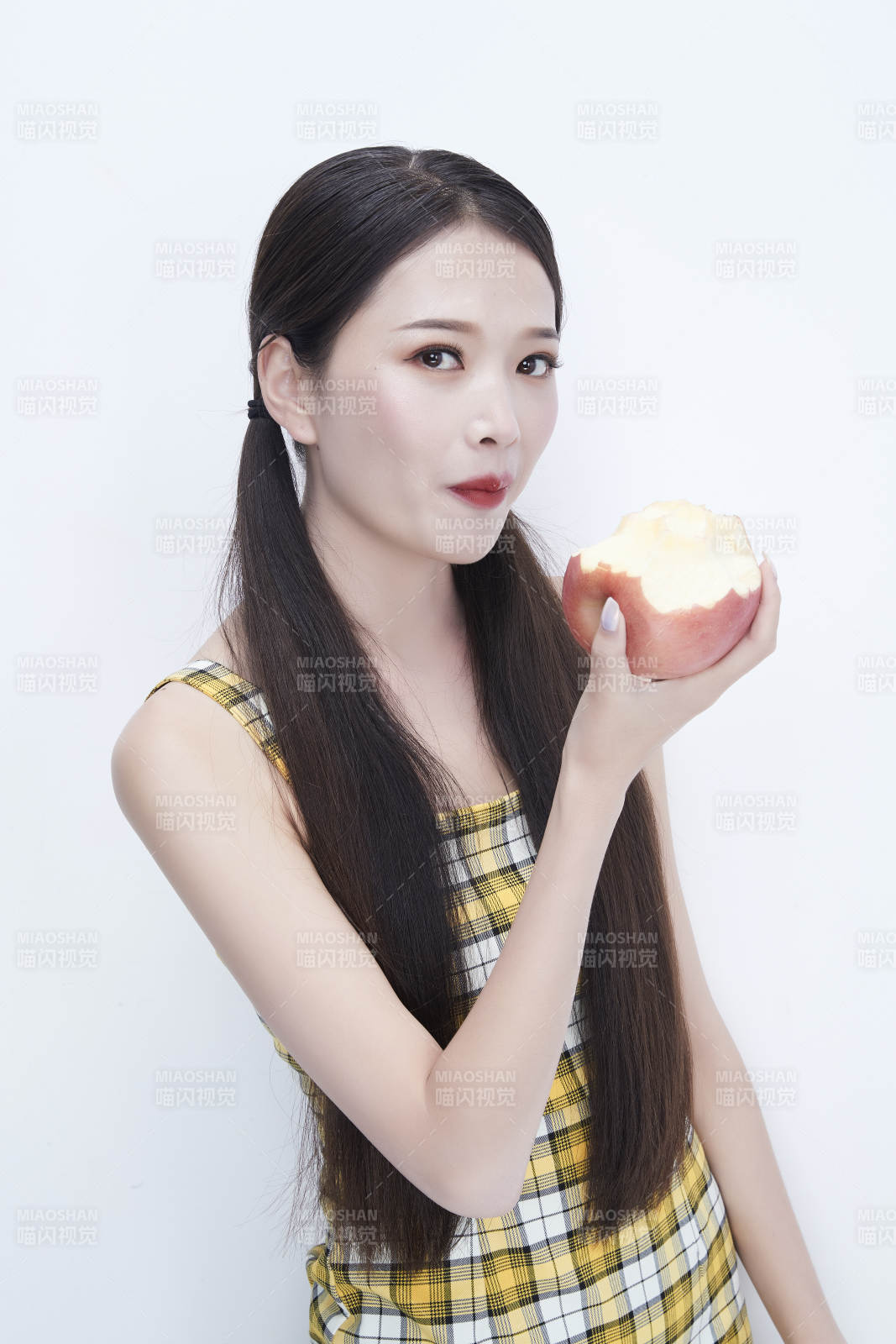 手拿蘋果身穿格子吊帶裙的亞洲可愛少女人像