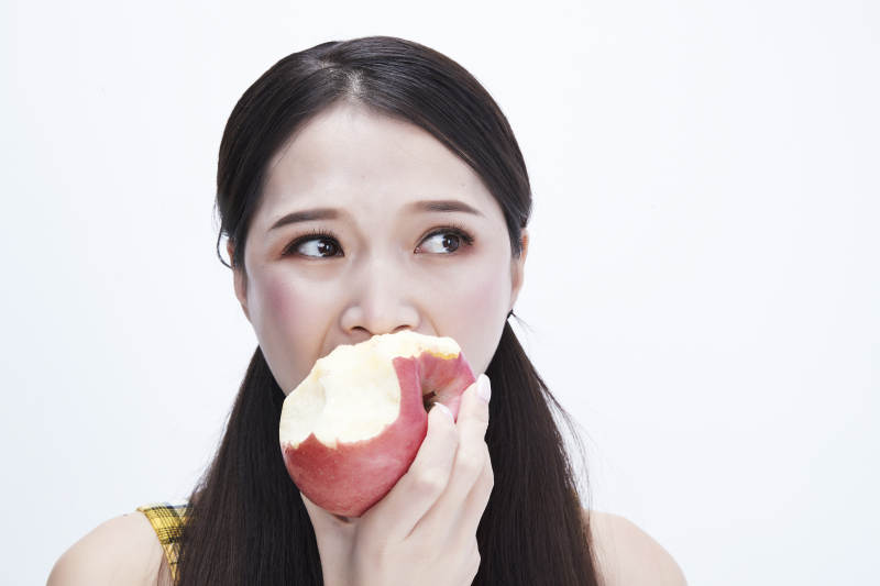 手拿苹果身穿格子吊带裙的亚洲可爱少女人像