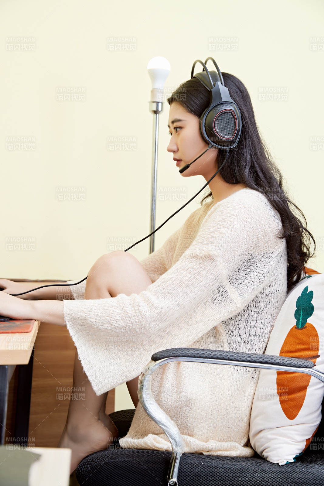 在家里坐在椅子上打游戏的美丽女孩